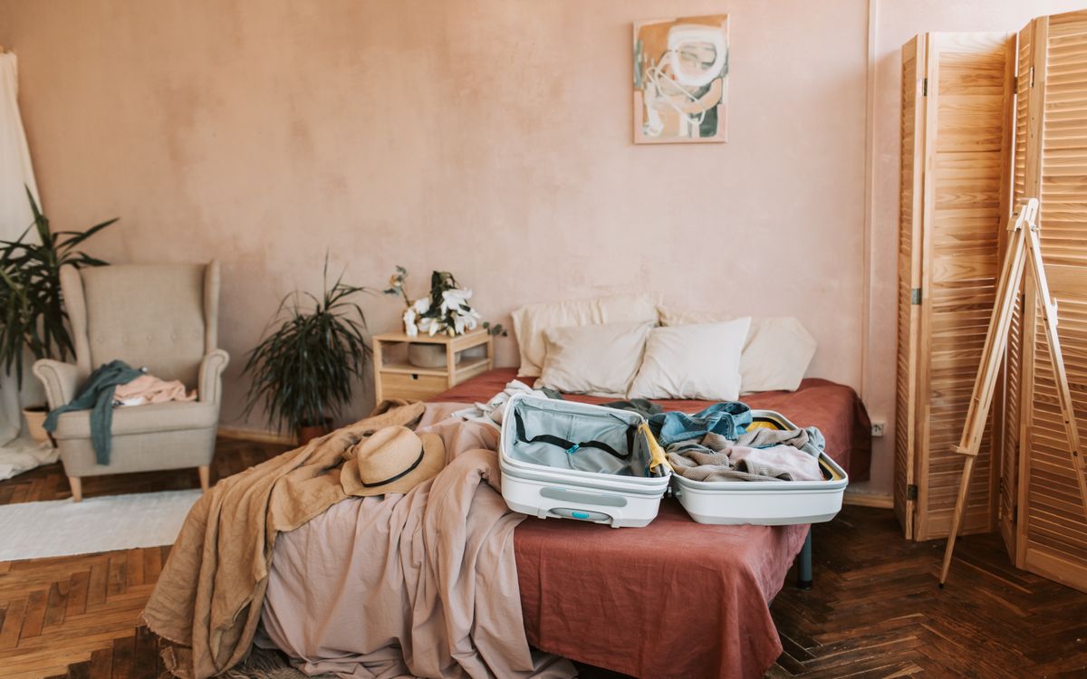 A white suitcase open on a bed