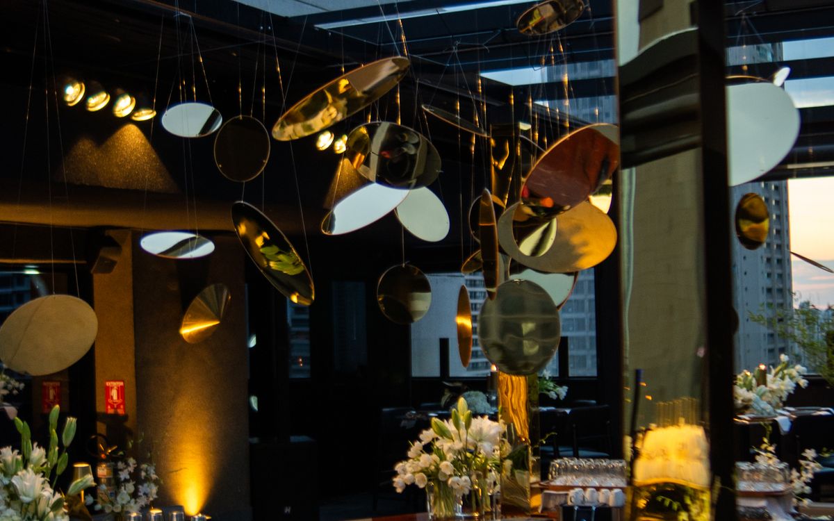 A rooftop dinner at dusk — string lights, a long table, guests in knit layers and wool coats