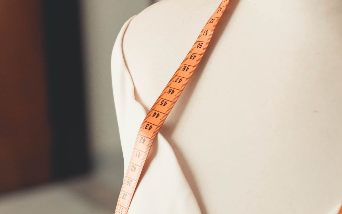 A measuring tape draped over a tailor's dress form
